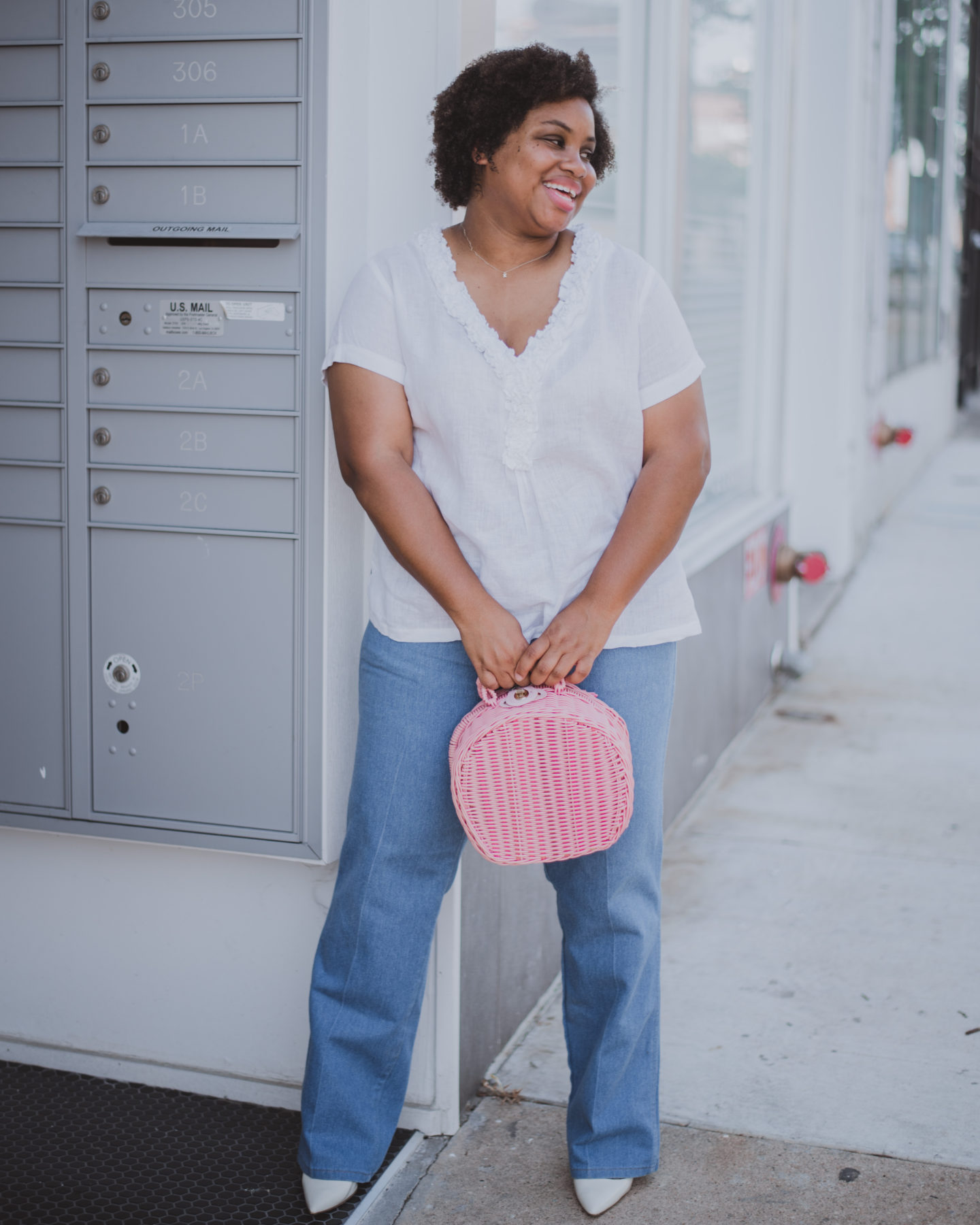 woman holding pink straw bag